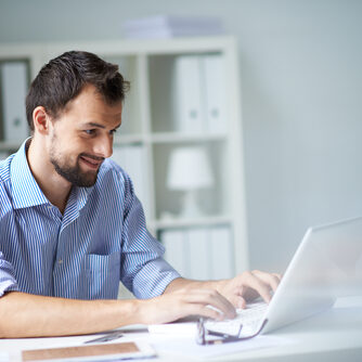 Handsome,Businessman,Working,With,Laptop,In,Office